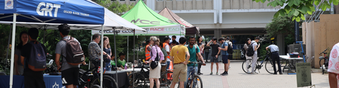 People outside at booths attending a bike fair on University of Waterloo campus