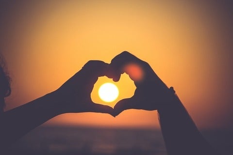 Hands forming a heart with sun in the middle