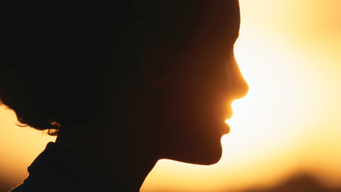 Silhouette of a women with a sun set in the background 