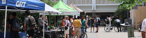 People outside at booths attending a bike fair on University of Waterloo campus