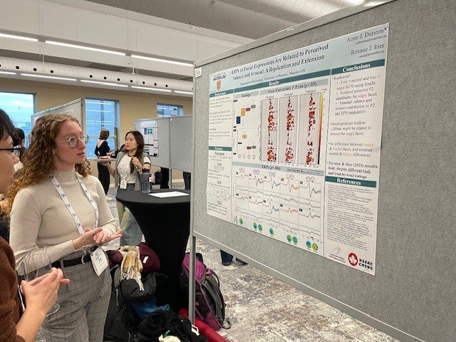 Amie explaining her poster to an audience member