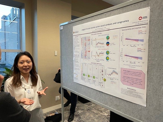 Zora explaining her poster to an audience member