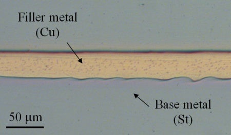 Brazed joint with copper filler metal and strontium base metal at 50 micrometer magnification.