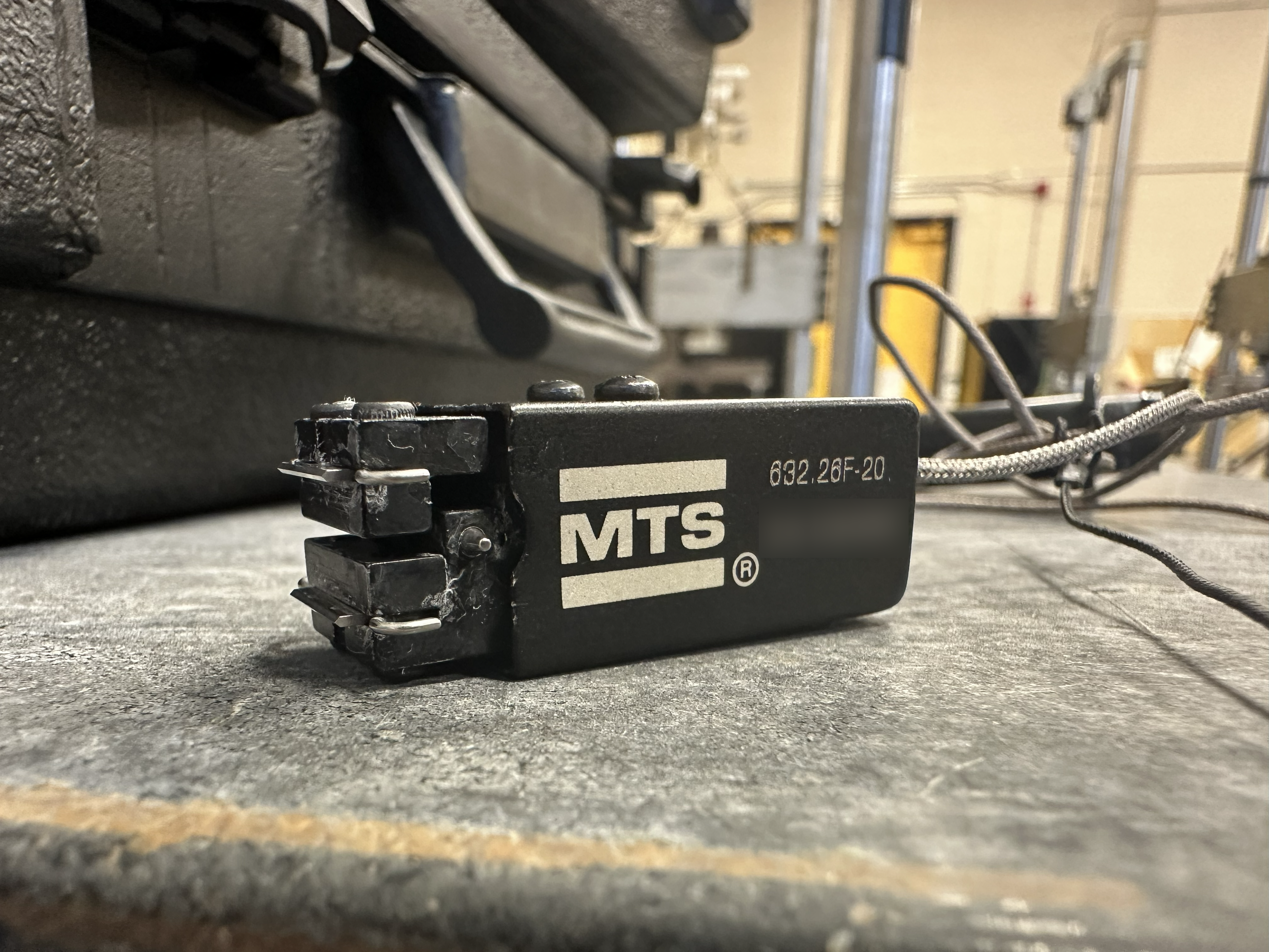 A black, long extensometer.