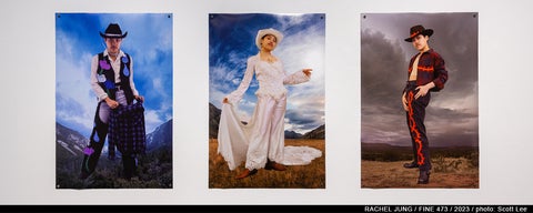 Three large photographs of a posed figure superimposed on a landscape. The person is dressed in three different costumes with a western/cowboy aesthetic that is altered to question gender stereotypes.