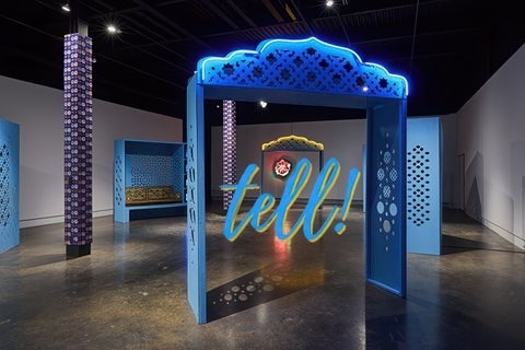 A ribbon of blue neon accentuates the peak of an azure-coloured architectural gateway perforated with Islamic ornamental patterns. Several similarly constructed shadow boxes are located throughout the gallery defining a semi-circular area for contemplation and interaction.