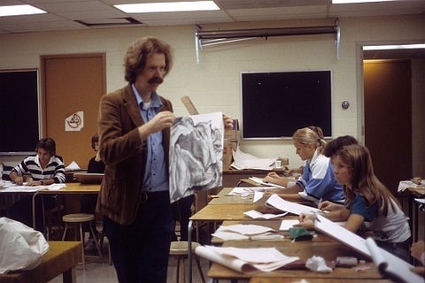 Instructor showing a drawing to students in the 1990s.
