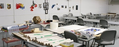 Fine arts studio classroom with table filled with paper and supplies