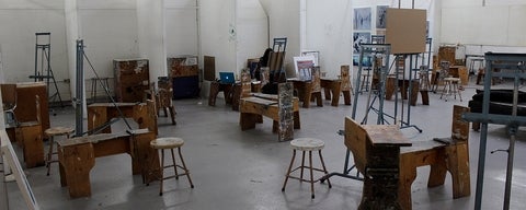 Art studio with easels, stool and wooden seats.