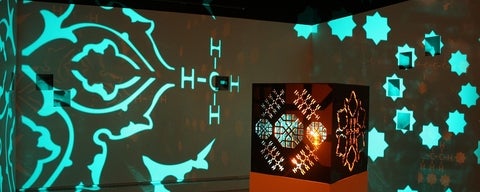 Artwork is gallery, light shines from a box in the centre of the room throwing projection of Islamic patterns and chemical compounds on the walls.