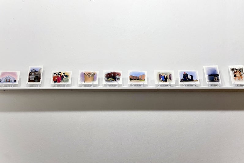 Artwork of 10 watercolour-like postcards showing architecture and people, displayed on a shelf.