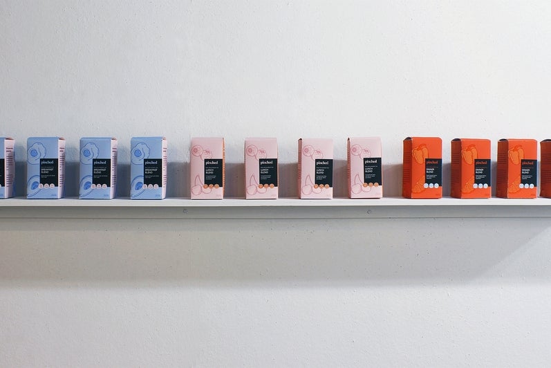 Art installation of shelf with 12 boxes of packaging for fake tea that read "Breakfast Blend, Lunch Blend, Dinner Blend" I'm 