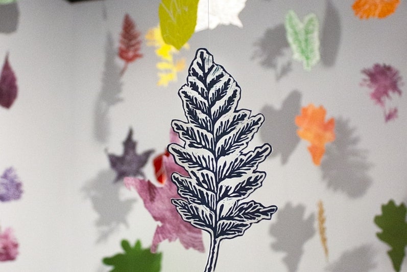 Detail of a lino print leaf in an installation of mutiple leaves from on string from the ceiling.