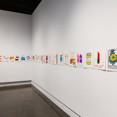 Series of colourful drawings of everyday objects with humorous or ironic text, all pinned to the wall in a row.