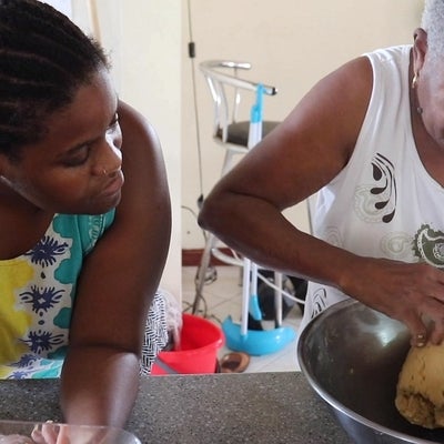 Video still, close up view of younger person watching older person mix dough with their hands