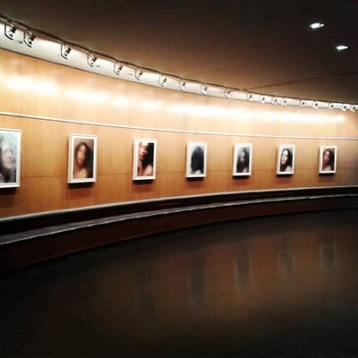 Gallery installation of portrait photographs showing person looking through condensation covered glass