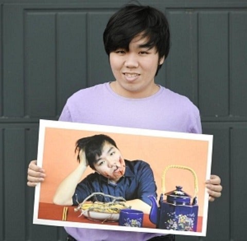 David Nguyen holding a digitally altered photographic self portrait