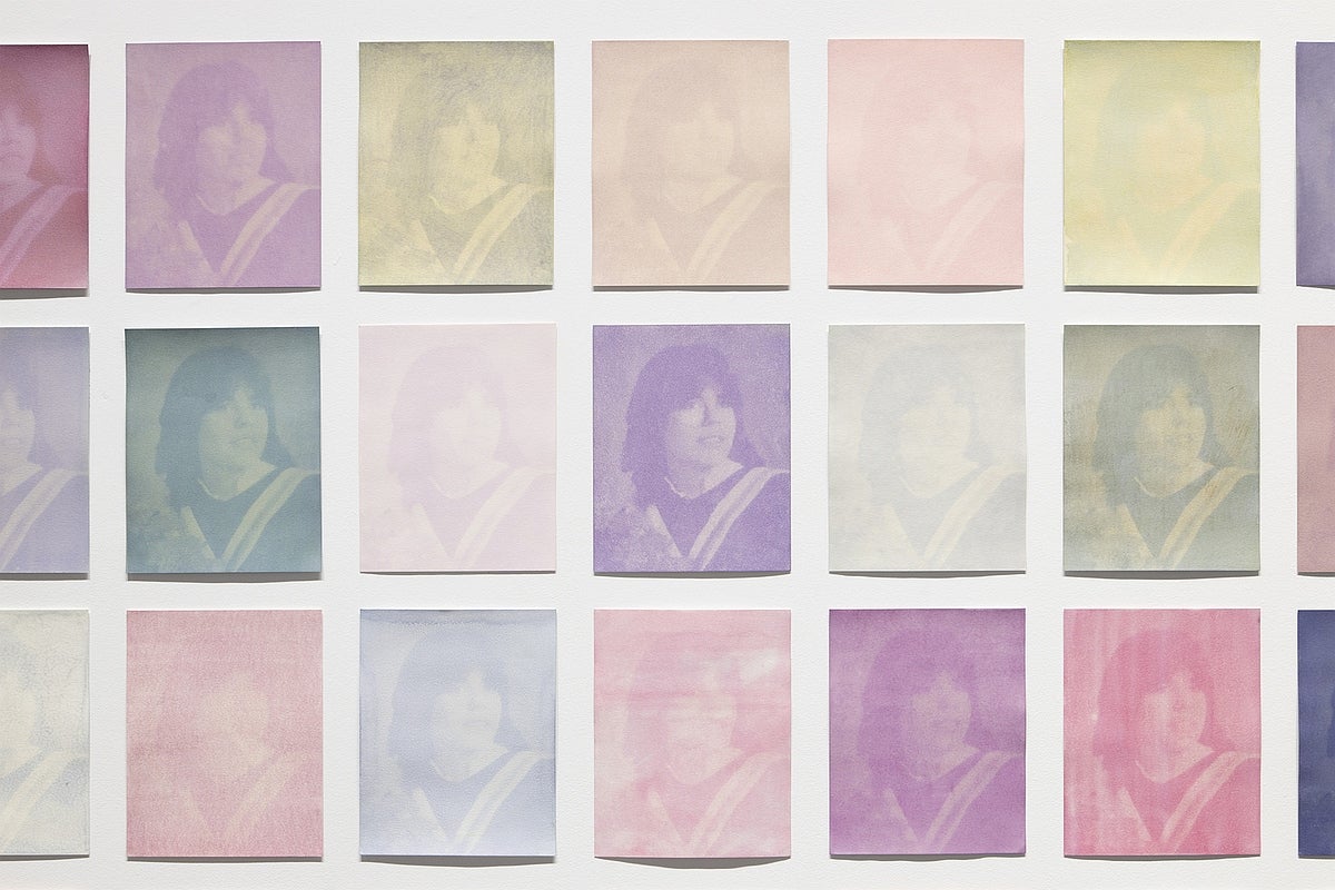 Detail of 44 multi-coloured prints of a graduation photo arrange in a grid pattern.