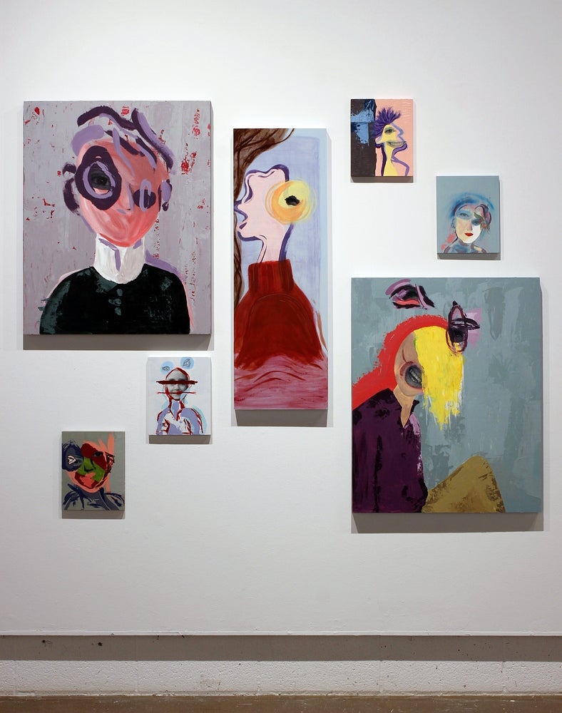 Gallery with seven painting of various sizes hung in a random pattern. Painting are colourful abstracted portraits is a fragment