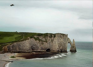 The ocean, cliffs and rock arch at Falaise d'Amont in France.