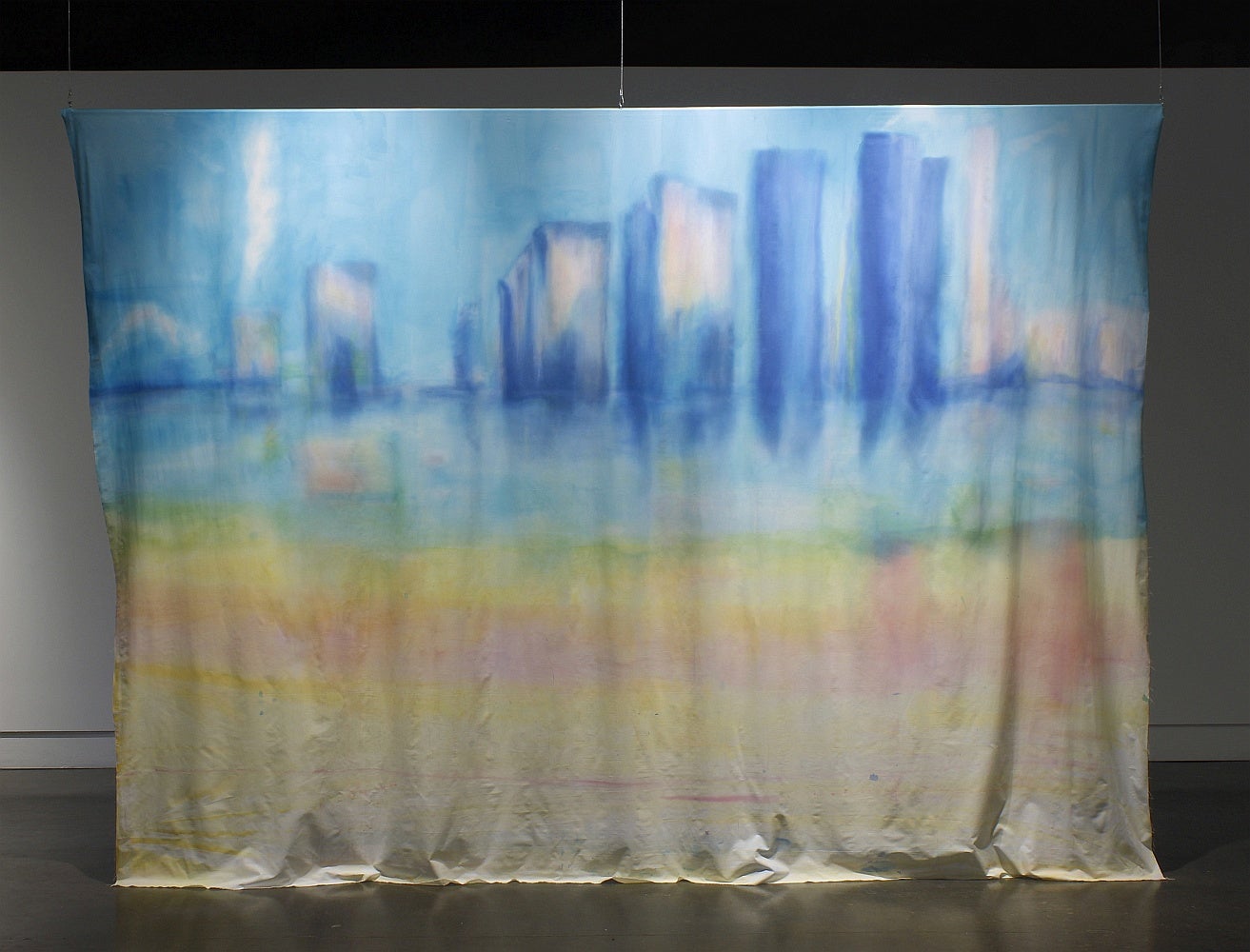 Ink wash painting of a cityscape, on a large canvas sheet, suspended from the ceiling..