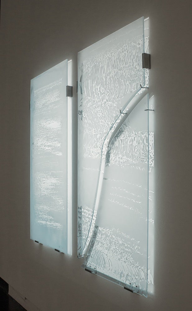 Light is projected onto glass panels, sandblasted with a pattern from medical imaging, which are hung away from the wall causing the light to be shine through.