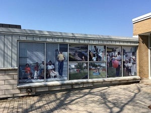 Large scale photographic installation of family on photos from the 1960s installed on the windows of a building