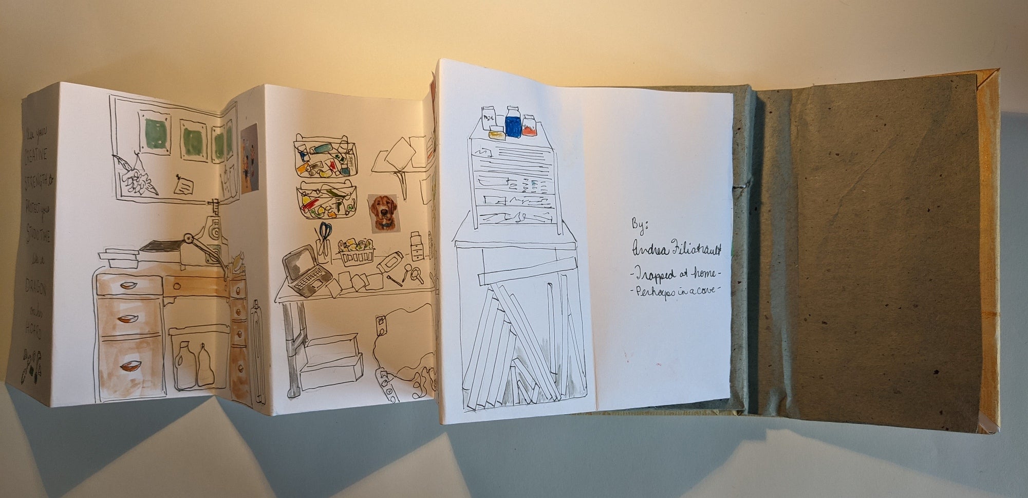 Accordion style book opened to back pages showing desks and tables with art supplies, Text Andrea Filiatrault Trapped at home,