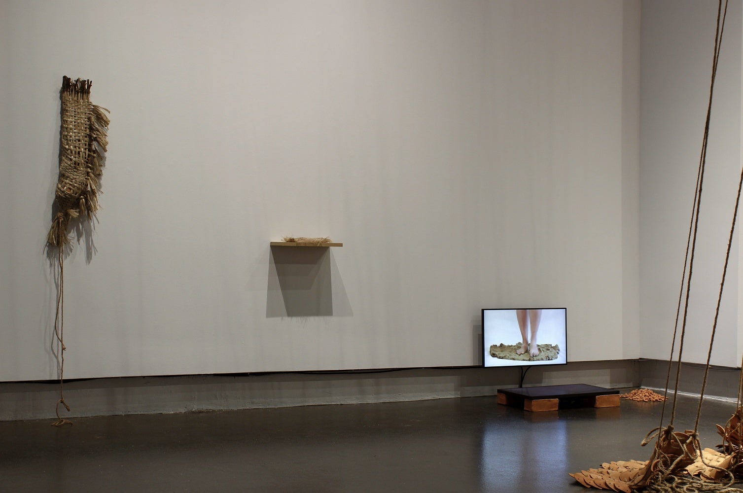 Art gallery with installation of a video and woven jute textile sculptures. 