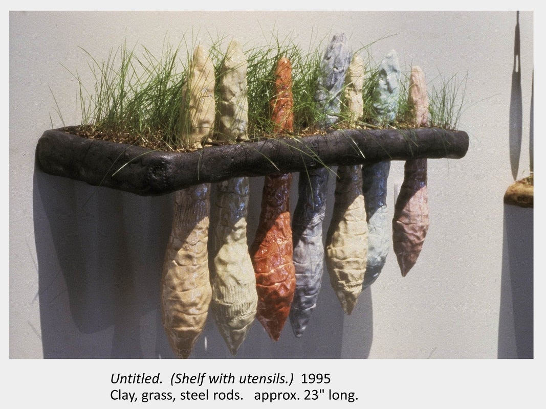 Artwork by Carol Bradley. Untitled.  (Shelf with utensils.) 1995. Clay, grass, steel rods. approx. 23" long.