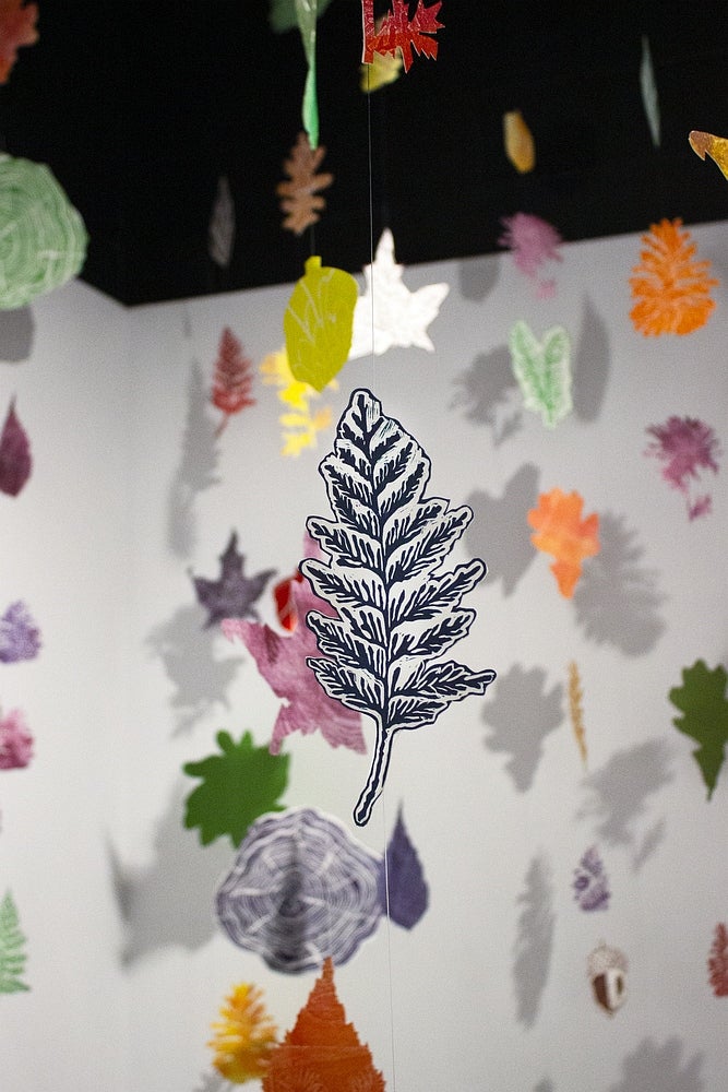 Detail of a lino print leaf in an installation of mutiple leaves from on string from the ceiling.