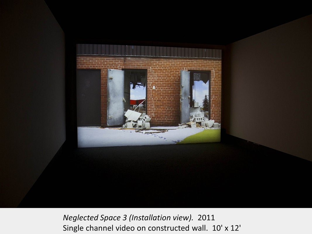 Artwork by Garl Carlson. Neglected Space 3 (Installation view). 2011. Single channel video on constructed wall. 10' x 12'