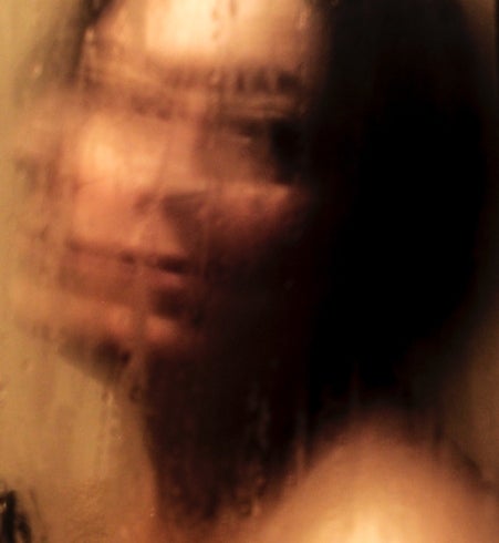 Colour photograph showing person looking through condensation covered glass