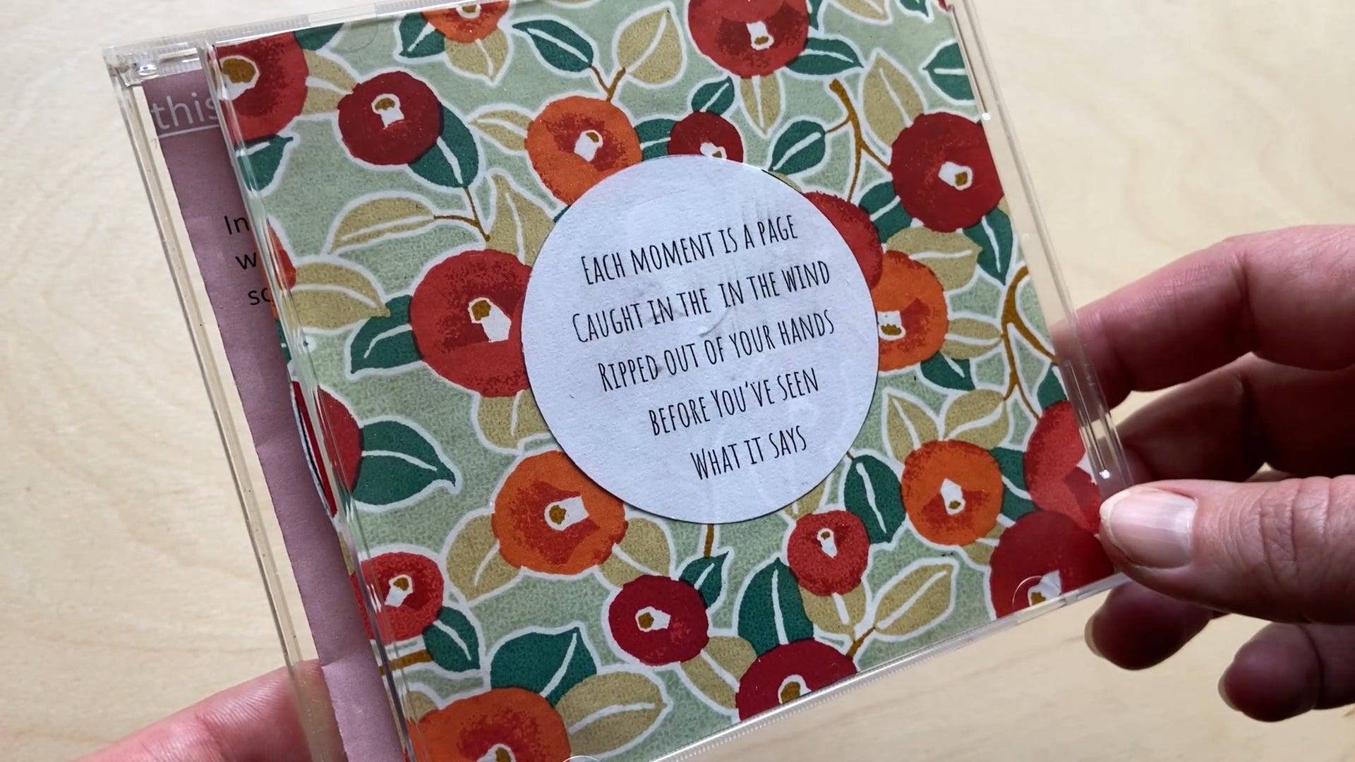 Artwork, CD case with floral paper insert and text "EACH MOMENT IS A PAGE CAUGHT IN THE WIND RIPPED OUT OF YOUR HANDS BEFORE YOU