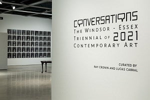 View of art gallery installation, wall label reads Conversations Windsor Essex Triennial of 2021 Contemporary Art