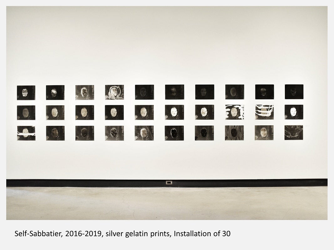 Gallery installation of 30 black and white prints of same portrait manipulated in various ways
