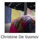 Art gallery filled with hanging bed sheets and inflated fabric sculpture in foreground and text "Christine De Vuono"