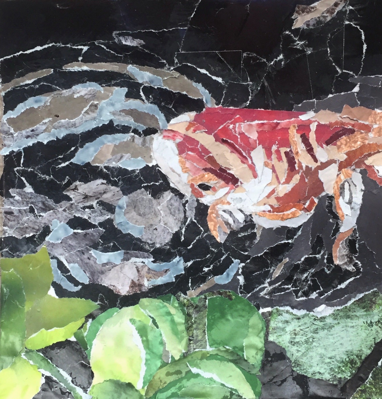 Paper collage of a fish swimming in dark water, green foliage at bottom.