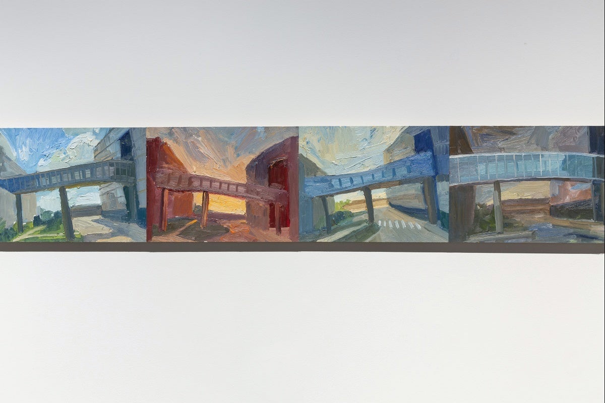 Detail of four small, colourful paintings and hung edge to edge in a line.  The paintings show views of a pedestrian overpass between building. 