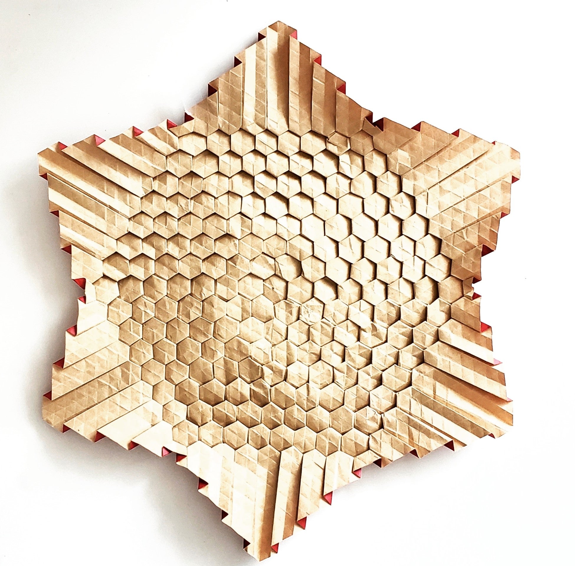 Cream coloured six pointed star with textured surface.