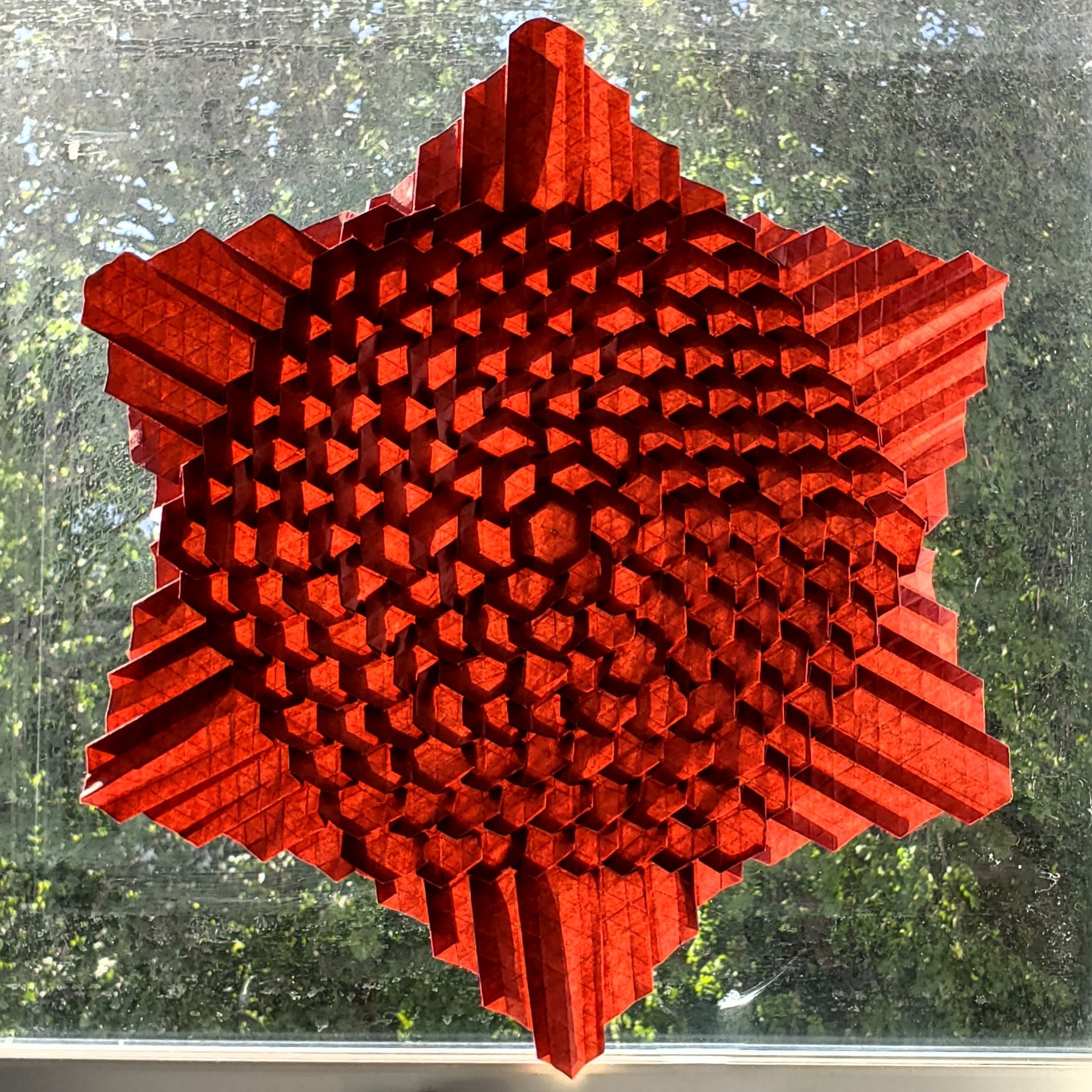 Red six pointed star with textured surface.