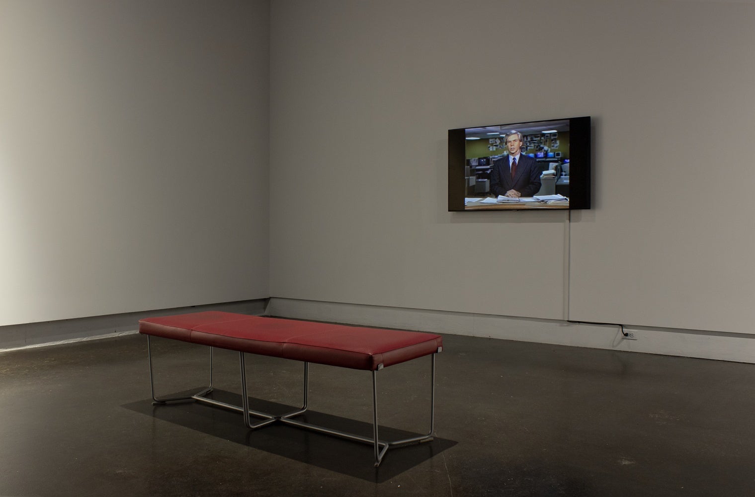 Bench seating in front of a screen playing an AI generated 1980s documentary about the Victory Box project