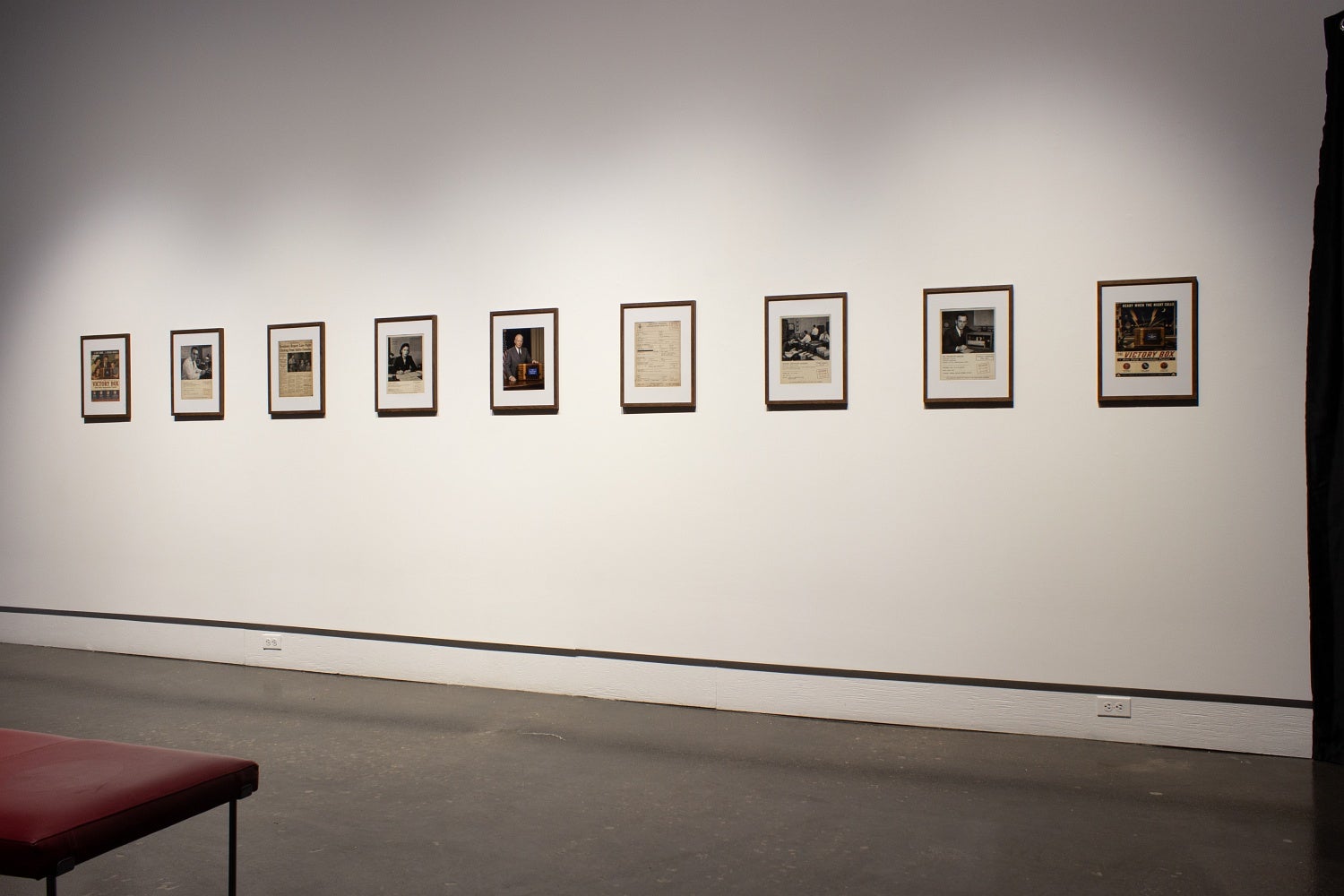 Nine framed AI generated vintage documents, photos and newspaper clipping about the fictional Victory Box project.