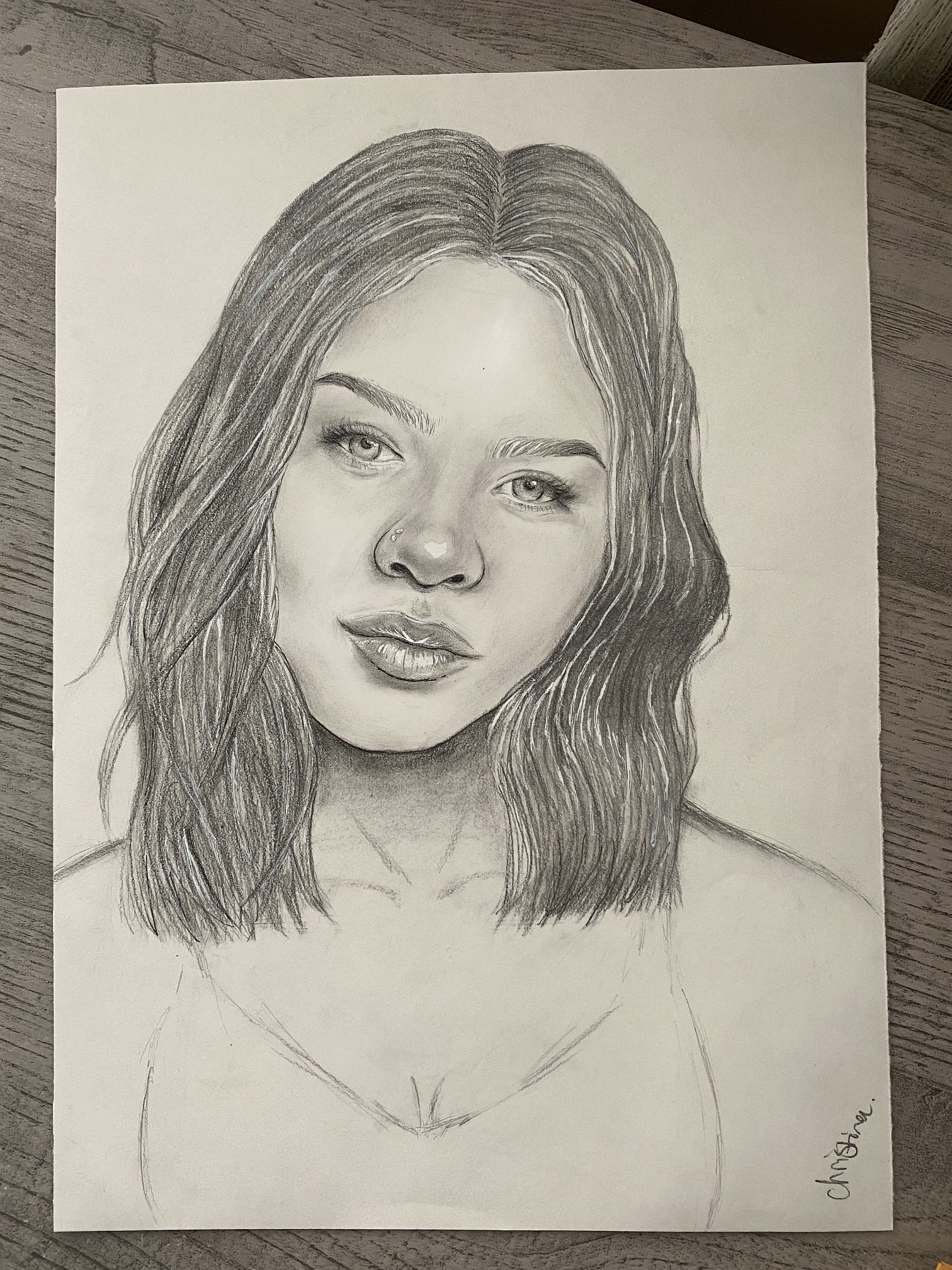 Portrait drawing showing person facing straight ahead with a faint smile and head tilted to the right.