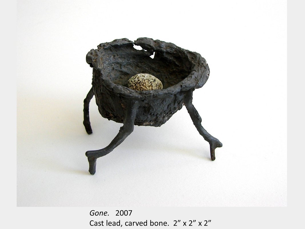 Artwork by Amy Switzer. Gone. 2007. Cast lead, carved bone. 2” x 2” x 2”
