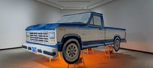 Sculpture of a full size blue Ford truck made from paper and painted with watercolour