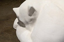 Close-up of an idealized sculpture of sled dog curled up and sleeping.