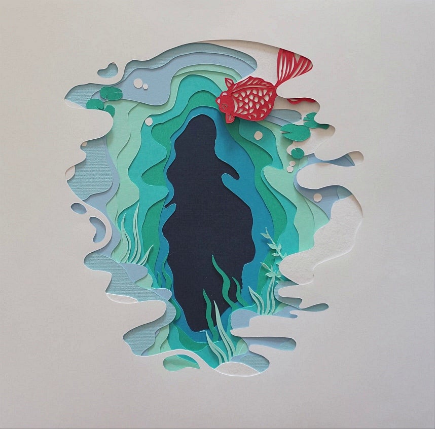 Paper cut-out artwork, white paper cut to reveal pages in shades of blue and green like water, orange carp swims.