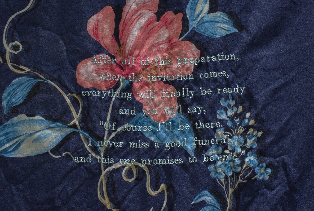 Detail of an artwork, text embroidered on fabric: After all of this preparation, when the invitation comes, everything will finally be ready and you will say, "Of course I'll be there, I never miss a good funeral and this one promises to be epic."