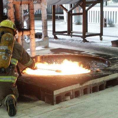 Firefighter lighting JP8 "spill" fire.